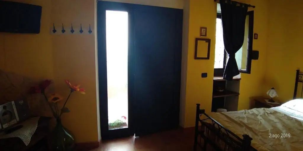 Ingresso indipendente de Il Borgo 31: porta scura con vetrata verticale, appendiabiti a parete e televisore.